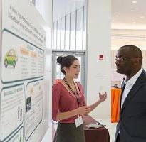 poster presenter speaking with attendee